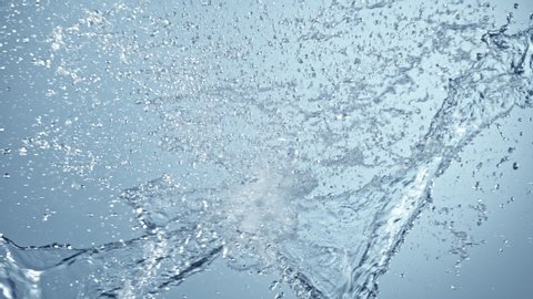 Super Slow Motion Shot of Side Water Splash on Blue Gradient Background at 1000fps.