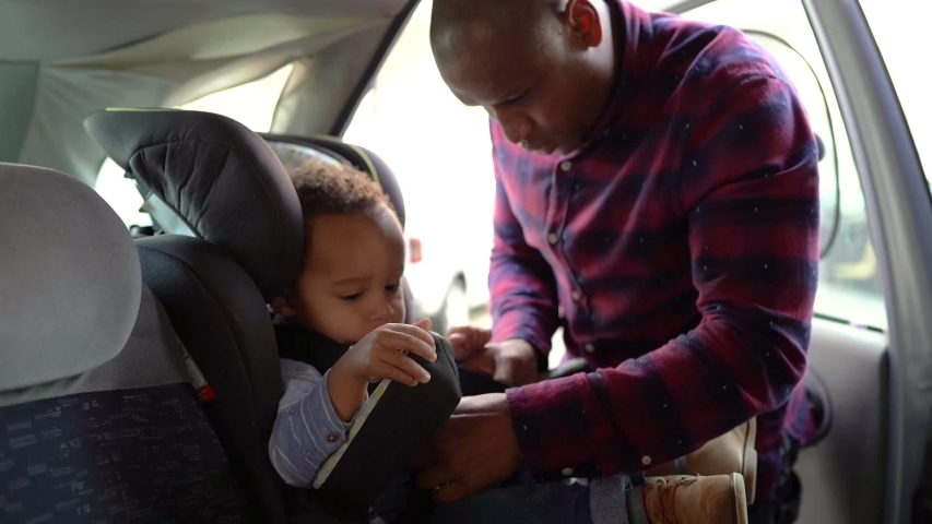 African American bald dad checking belts on child car seat. Focused young father protecting in case of emergency. Safety and transportation concept | Shutterstock HD Video #1054954454