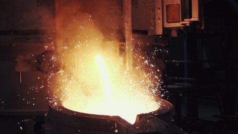 A big beautiful bright splash of yellow hot  metal sparks. Steel Cast at Metal Production Plant, slow motion