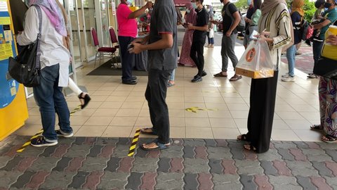 Melaka/Malaysia - June 21,2020 : 4K real time footage of people line up before entering shopping mall. Screening and scanning QR code using MySejahtera application is a must in Malaysia. New Normal