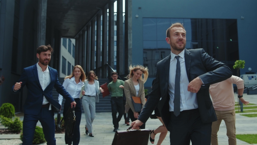 Multi-ethnic group of co-workers dancing funny on outdoor street. Happy satisfied business men and women with boss dancing on to rejoice corporate victory. Royalty-Free Stock Footage #1054967618