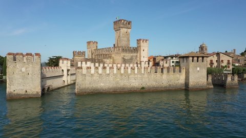 Sirmione, Lake Garda, Italy. Aerial view of Sirmione Castle. A close view of the Italian flag on the main tower. Blue sky