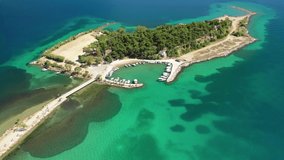 Aerial drone video of famous island of dreams or Pesonisi connecting with small road with seaside fishing village of Eretria, Central Evia island, Greece