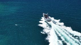 Aerial drone tracking video of luxury inflatable speed boat cruising in deep blue Aegean sea, Mykonos island, Cyclades, Greece