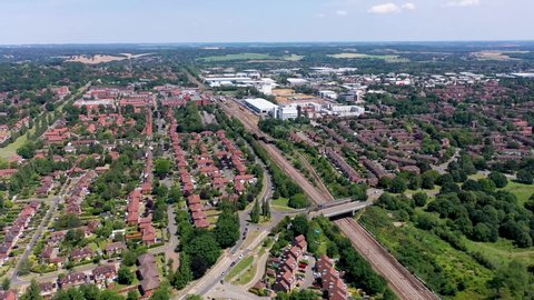 Top down aerial footage of the suburban houses and village of Welwyn Garden City in Hertfordshire taken on a hot sunny summers day showing a drone view of the typical British housing estate