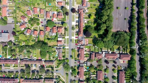 Top down aerial footage of the suburban houses and village of Welwyn Garden City in Hertfordshire taken on a hot sunny summers day showing  a straight down view of the typical British housing estates