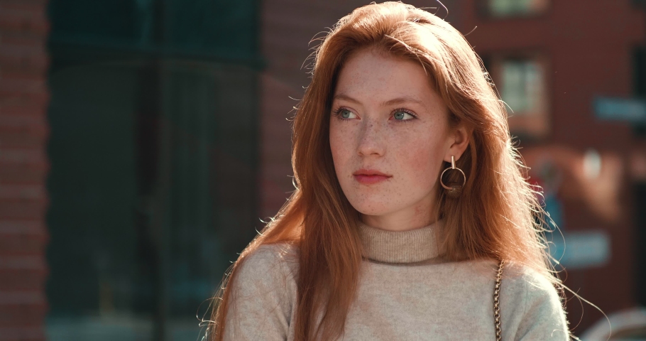 Ginger Pretty Woman with Confident look and Attractive Appearance Looking at Camera. Female model with natural beauty and lovely freckles on her Face. Having long Red waving Hair. Royalty-Free Stock Footage #1054990826