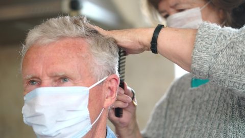 Female Barber Cuts Man's Hair, Professional Hairdresser With Face Masks On.