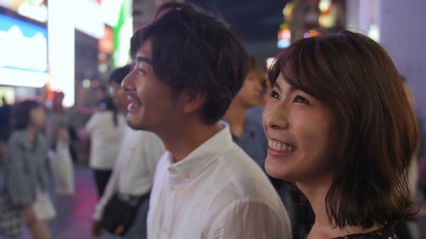 Beautiful Asian women walking through Osaka streets at night with Boyfriend tourism in Japan 