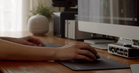 Close up of female's hand navigating computer program with mouse in her home office