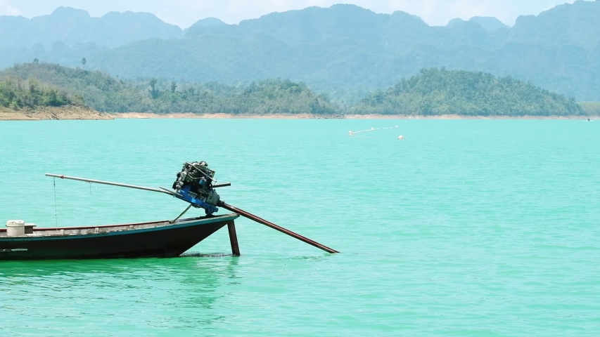 thai traditional wooden long tail boat on water lake at “Cheow Lan Dam (Ratchaprapha Dam)”khao sok national park Suratthani Thailand.