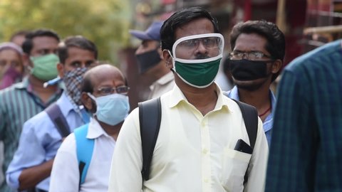 MUMBAI/INDIA- JUNE 15, 2020: Commuters wearing a facemask wait to board a public transport bus in Dombivali. India has begun gradually lifting its restrictions imposed by the government.
