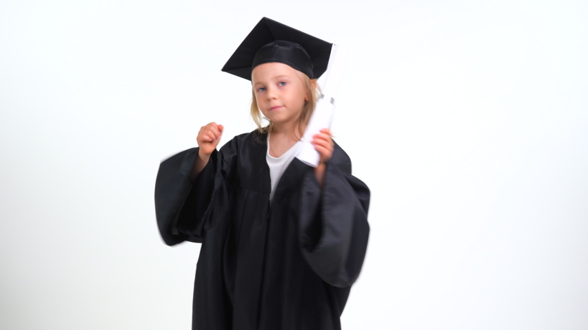 Portrait Happy little graduate celebrating with her graduation cap and toga. Happiness success concept Graduation Proud silly girl on white background Royalty-Free Stock Footage #1055001782
