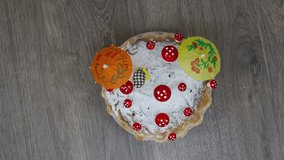 Fresh baked homemade cake with sugar powder and decorated with mushrooms and chick toy on wooden table background.