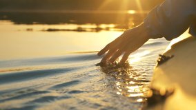 man puts fingers down in lake kayaking against backdrop of golden sunset, unity harmony nature - Powered by Shutterstock - Get 15% off with code: PIKWIZARD15