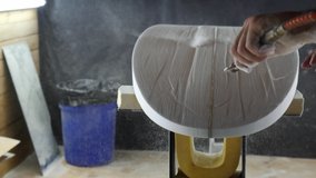 Surfboard making, Shaper using a foam sander tool on the bottom of the surfboard. Concept of craftsmanship, small business in America, craftsman at work. - Powered by Shutterstock - Get 15% off with code: PIKWIZARD15