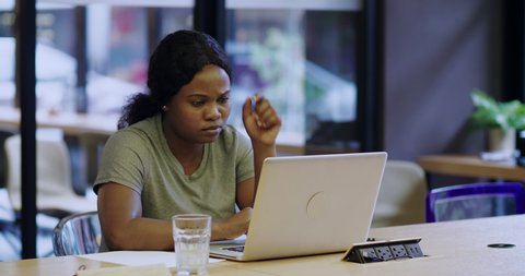 One African businesswoman using laptop in the office with problem unhappy thoughtful anxious Black student facing problem thinking typing on computer