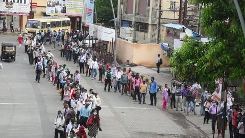 MUMBAI/INDIA- JUNE 15, 2020: Commuters wearing a facemask wait to board a public transport bus in Dombivali. India has begun gradually lifting its restrictions imposed by the government.