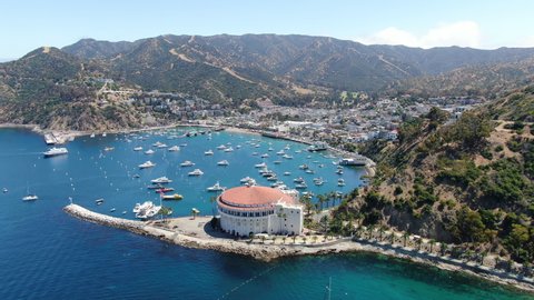 Aerial view of Catalina Casino and Avalon harbor with sailboats, fishing boats and yachts moored in calm bay, famous tourist attraction in Santa Catalina Island, Southern California. June 20th, 2020