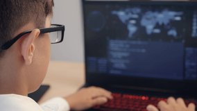 Portrait of child prodigy boy in glasses is programming the code at laptop at home. Young hacker works at a computer. - Powered by Shutterstock - Get 15% off with code: PIKWIZARD15