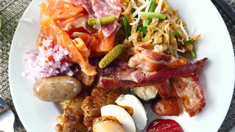Breakfast in Luxury Hotel with Noodle, Rice, Sausage, Salmon. Morning Eating with Plates Full of Fresh Food on the Table, Ready to Serve. Large Selection of Fresh Food in Restaurant, Overeating
