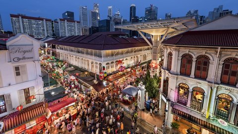 TL/ZI/ Asia, Singapore, Chinatown, 01-23-2020, Zoom In Time lapse of busy night market during Chinese New Year in Singapore's Chinatown in front of the Singapore skyline, at dusk