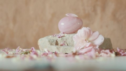 Rose petal fly away from Yoni rose quartz egg in a background of natural flesh-colored clay similar to human skin
A sacred instrument for intimate practices of female health and sensitization