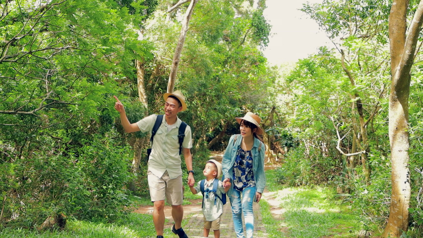 Happy family hiking through the forest