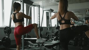 Strong girls warming up legs before workout at gym