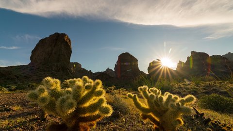 Time lapse of sunrise sky over cliffs and cholla cactus at Kofa National Wildlife Refuge in Arizona