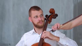 A man plays the cello. Panorama from top to bottom