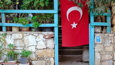 Turkish flag hanging on a country house in rural Turkey. Countryside scene in Turkey