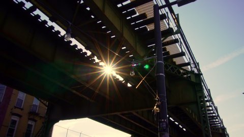 New York City camera moving under Train tracks with Sunlight and Flares. Cinematic feel.