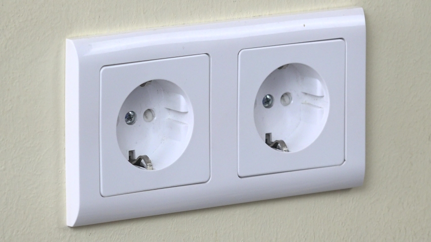 Man hand covered electricity outlet on wall with safety plugs (baby and child safety concept). 4K | Shutterstock HD Video #1055080943