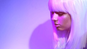 Fashion model woman in colorful bright sparkles and neon lights posing in studio, portrait of beautiful girl, white hair, trendy glowing make-up. Art design colorful make up. Glitter Vivid makeup. 4K
