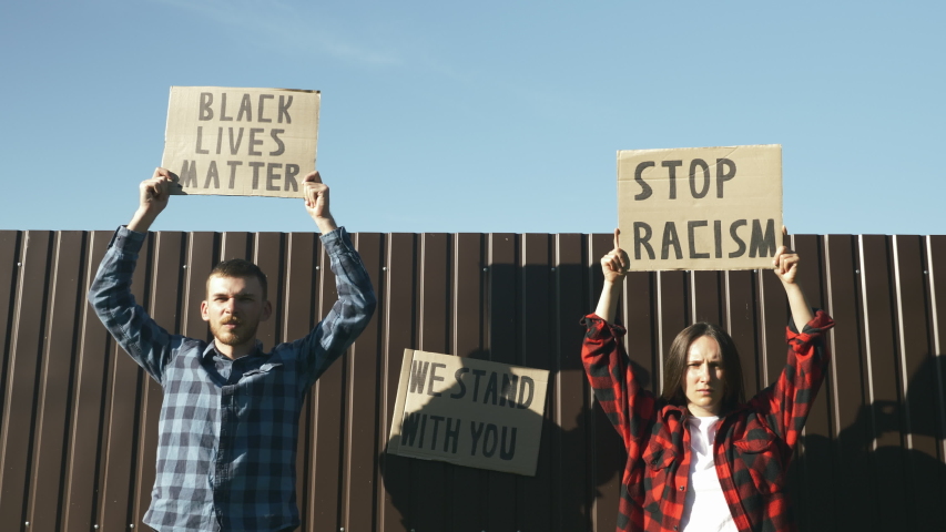 Multi-ethnic people protesting for equal rights hold poster Stop racism ...