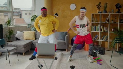 African american fat guy engaged in sports with fitness instructor doing light stretching warm-up exercises indoors. Funny workout. Training. Fun concept.