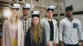 Likable high-skilled creative diverse team of male and female colleagues in augmented reality goggles working on imaginary screen in beautifully designeted office room - Powered by Shutterstock - Get 15% off with code: PIKWIZARD15