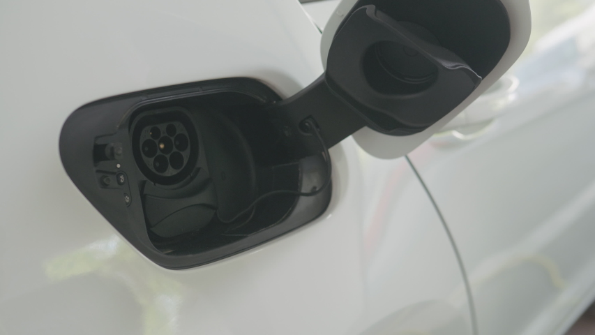 CU shot of a woman's hands plugging in her electric car to charge Royalty-Free Stock Footage #1055094377