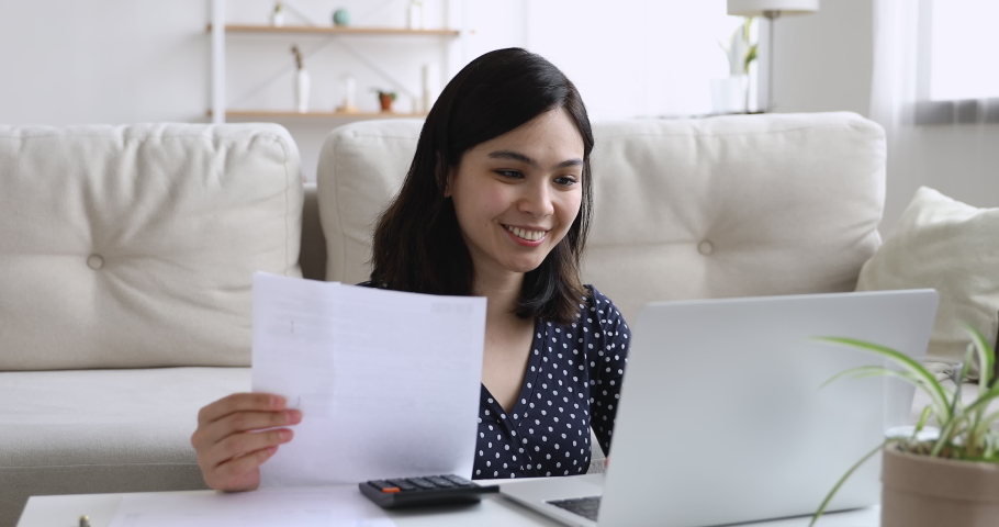 Happy asian woman sit at coffee table in living room manage household finances family budget make payments use laptop, calculate expenditures use calculator, do research, check home expenses concept Royalty-Free Stock Footage #1055094452