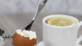 Homemade morning breakfast with boiled eggs and tea cup on wooden table background.
