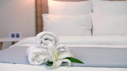 Chambermaid making bed in hotel room, focus on clean towels
