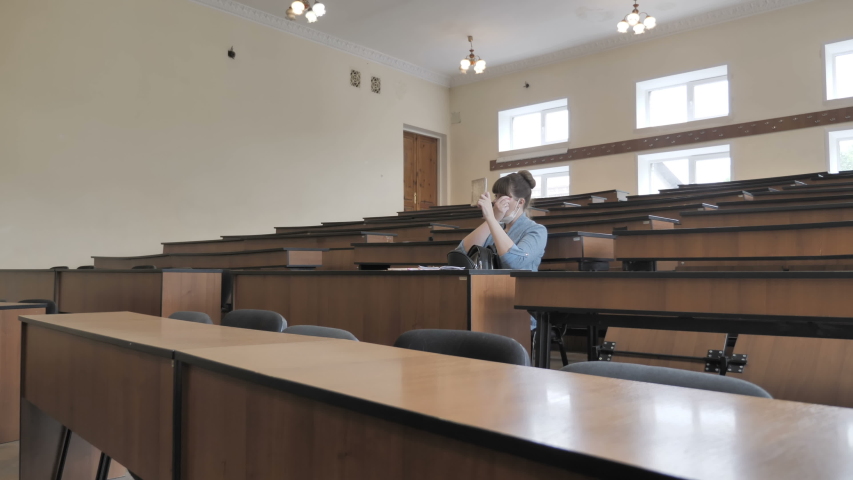 Girl Student Sitting In Auditorium During A Break Or Before Lecture  At University 