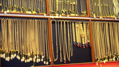 Close up of necklace on shelf at gold shop. Gold chains in the shop window of the jewelry store.