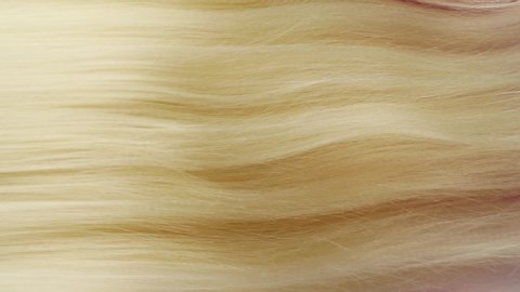 Slow motion of close-up of beautiful blond long smooth straight brown hair texture. Haircare concept, extensions, hair abstract background.