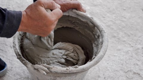 Worker mixing cement in the bucket in construction site