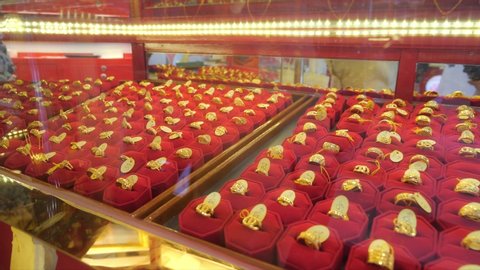 Rings gold jewelry in red velvet tray of rows selling in a market.