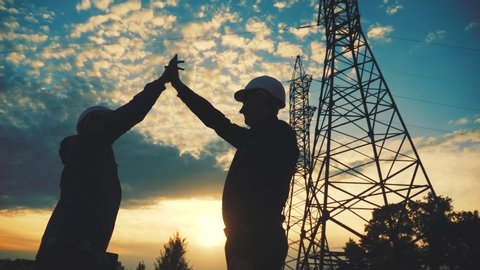 teamwork. two electricians engineer shake hands. business partnership energy technology industry a concept. silhouette two workers handshake lifestyle. teamwork in energy