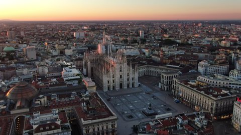 milan aerial view drone,wide shot of city center cathedral and piazza duomo at sunrise fly orbit no people