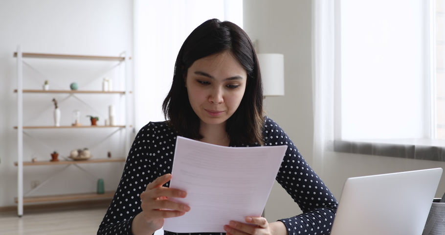 Happy Asian woman sit at desk read letter about college admission, scholarship approved, invitation for internship abroad. Got hired job of dream, bank loan accepted, moment of celebration of victory Royalty-Free Stock Footage #1055106542